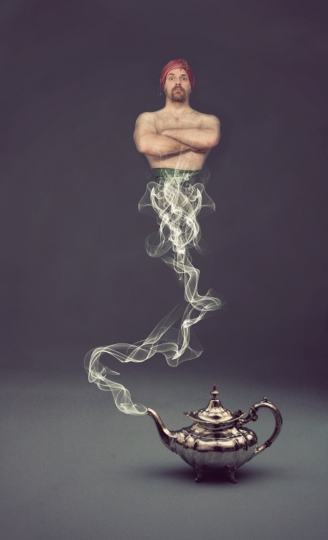 a man dressed as a genie coming out of a silver tea pot